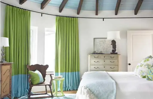 Một chiếc rèm cửa xanh lá cây với phần chân là màu xanh dương